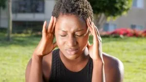 woman with a headacke as a symbol of fake negative reviews and the ways they can be hurtful