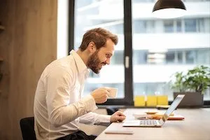 man working and drinking coffee