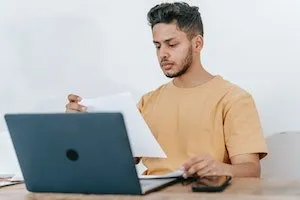 A man looking at papers to build backlinks for e-commerce websites