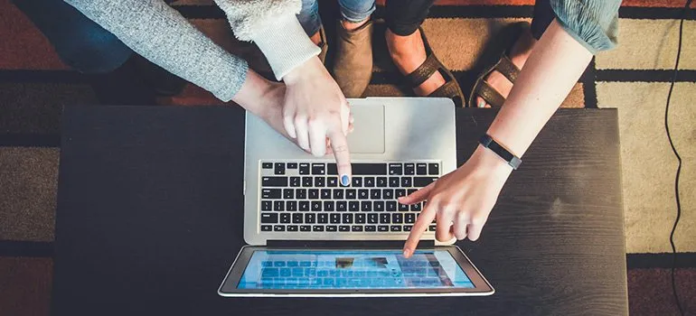 fingers pointing to something on a computer screen