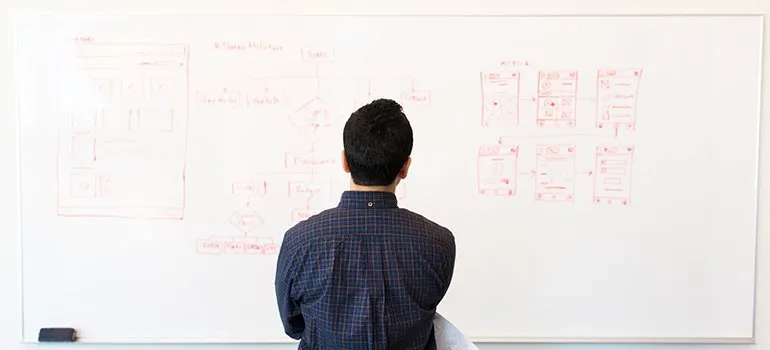 man reading from white board